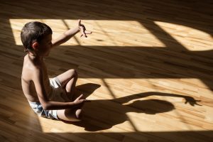 Charming little boy playing in theatre of shadows