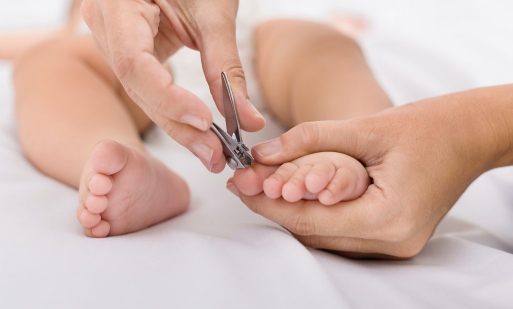 Mother cutting toenails for Baby close up
