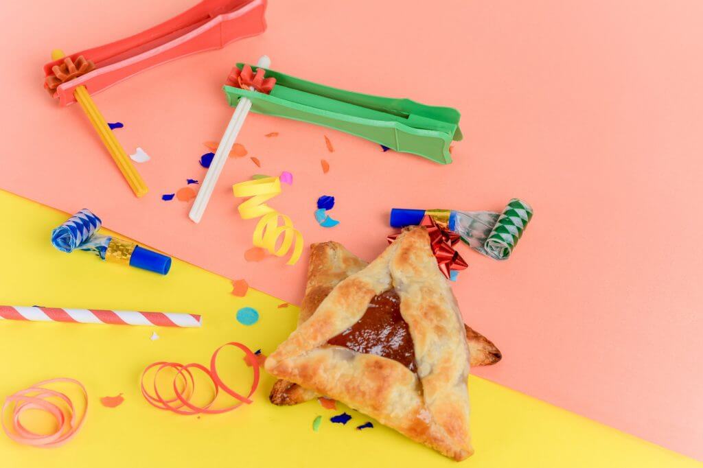 Purim background with party costume and hamantaschen cookies