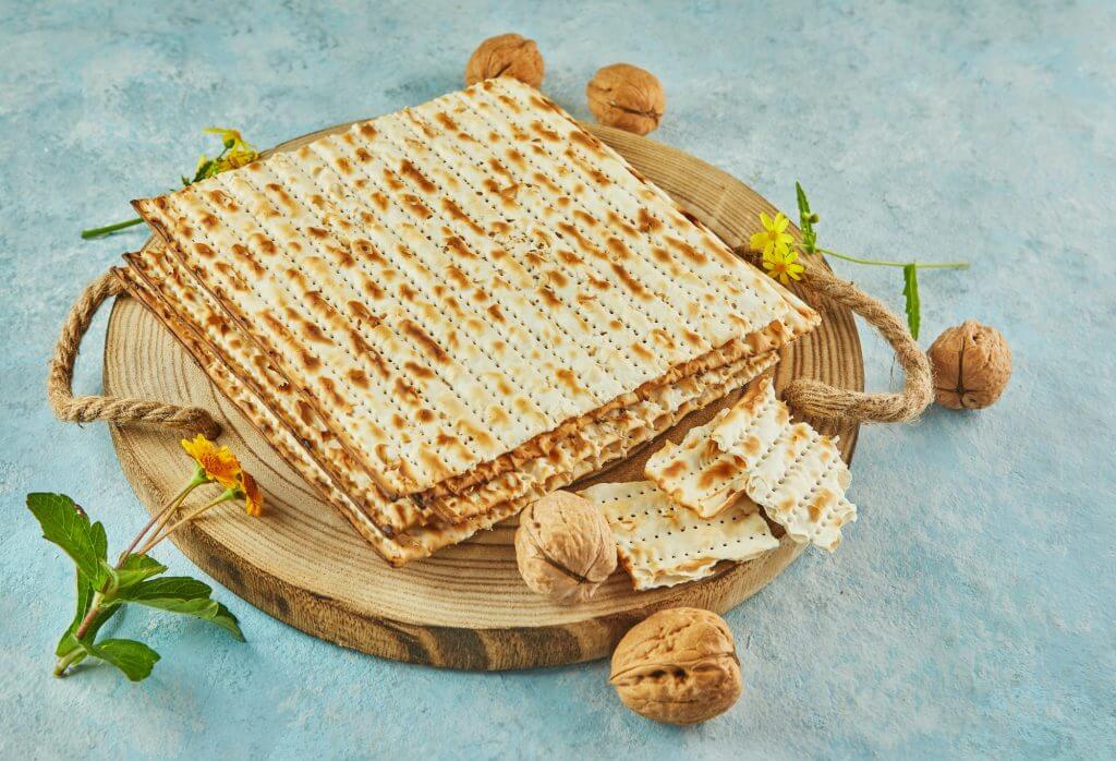 Pesach celebration concept - jewish Passover holiday. Matzah on wooden stand with nuts