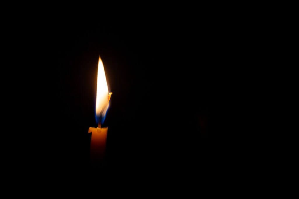 Burning candle isolated on black background, concept of mourning, sadness, sorrow. Commemoration day